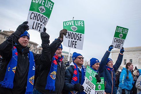 Knights of Columbus members at a pro-life march holding Love Life Choose Life signs