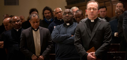 Catholic clergy and Knights of Columbus members gathered in prayer inside a church